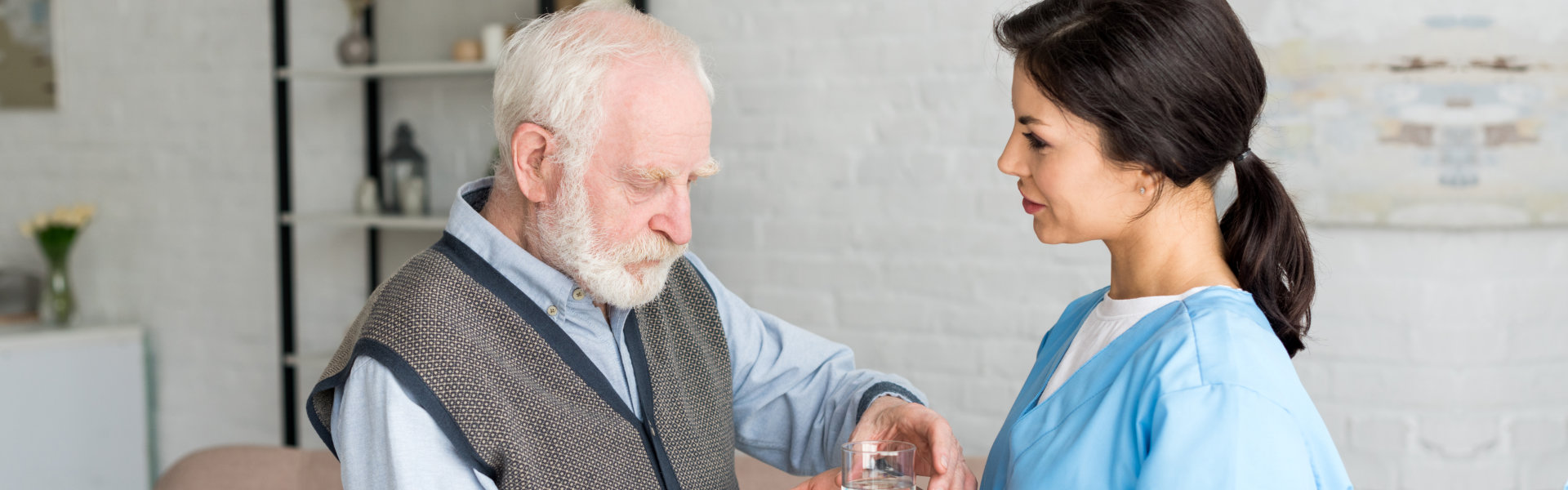 caregiver giving water to the elderly