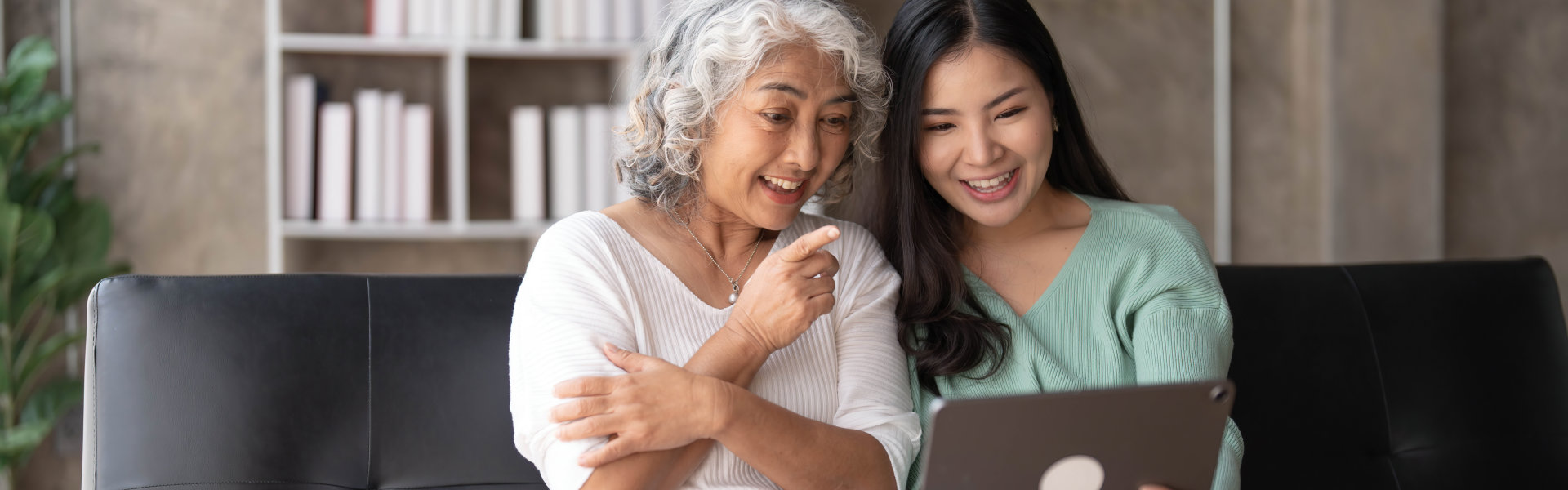 elderly and caregiver looking at laptop